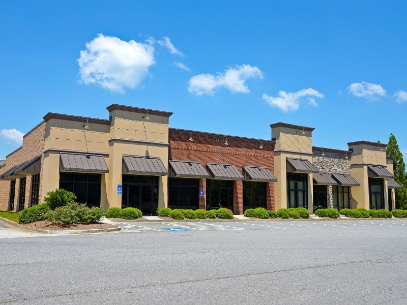 Neutral-toned strip mall exterior showing balanced commercial paint colours used for modern retail branding appeal.