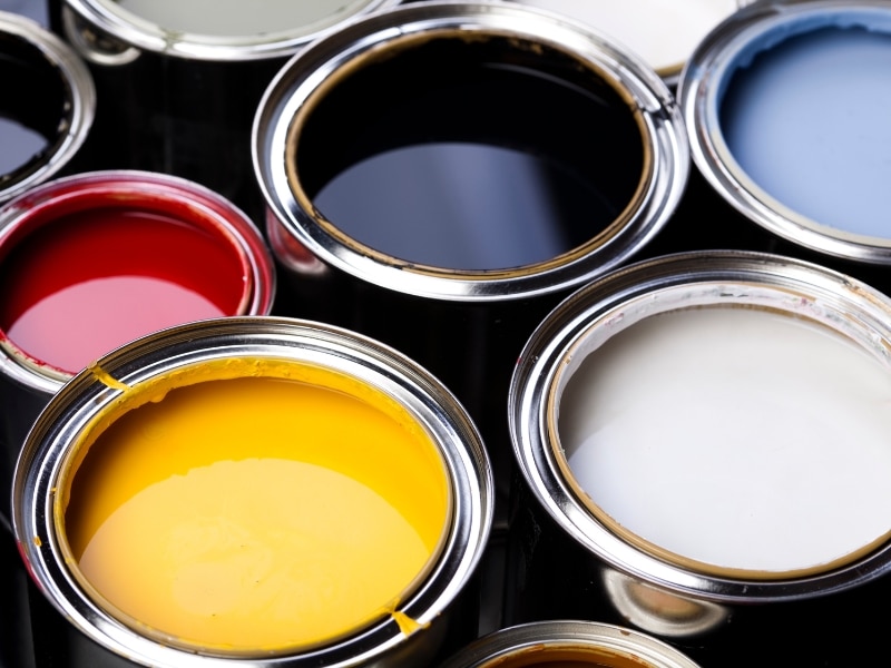 Assorted paint tins in vibrant shades representing commercial paint colours for different business types and moods.